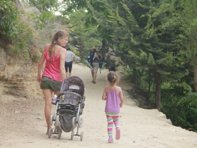 Familia caminando entre árboles por una ruta natural cerca de Luz de Sirius