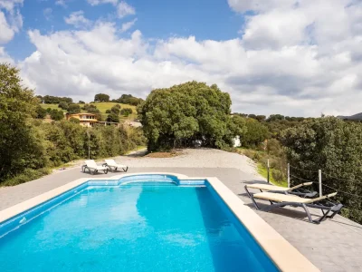 Piscina rodeada de árboles y hamacas en Luz de Sirius, espacio ideal para desconectar