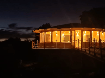 Fachada de la Sala Luz de Sirius iluminada por la noche, espacio para talleres y eventos en Luz de Sirius